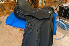 ZALDI-MOT-silla-doma-a-medida-negra-con-blanco-rodilleras-bajo-faldon-de-bienestarcaballo-3